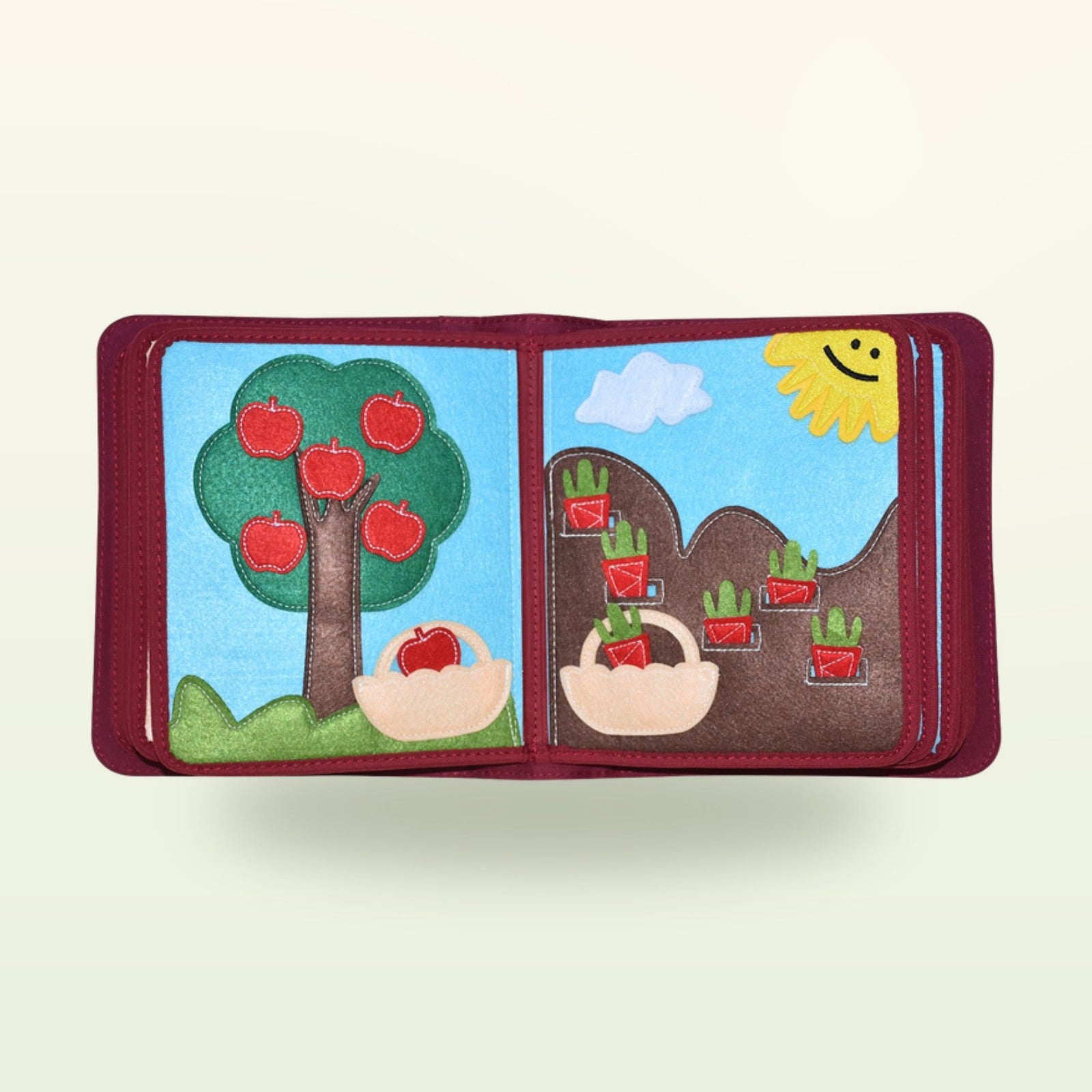 Mein Alltag Quiet Book Garten-Doppelseite mit Apfelbaum zum Pflücken und Karotten zum Ernten im Beet auf sanftem cremefarbenem Hintergrund – ab 1 Jahr