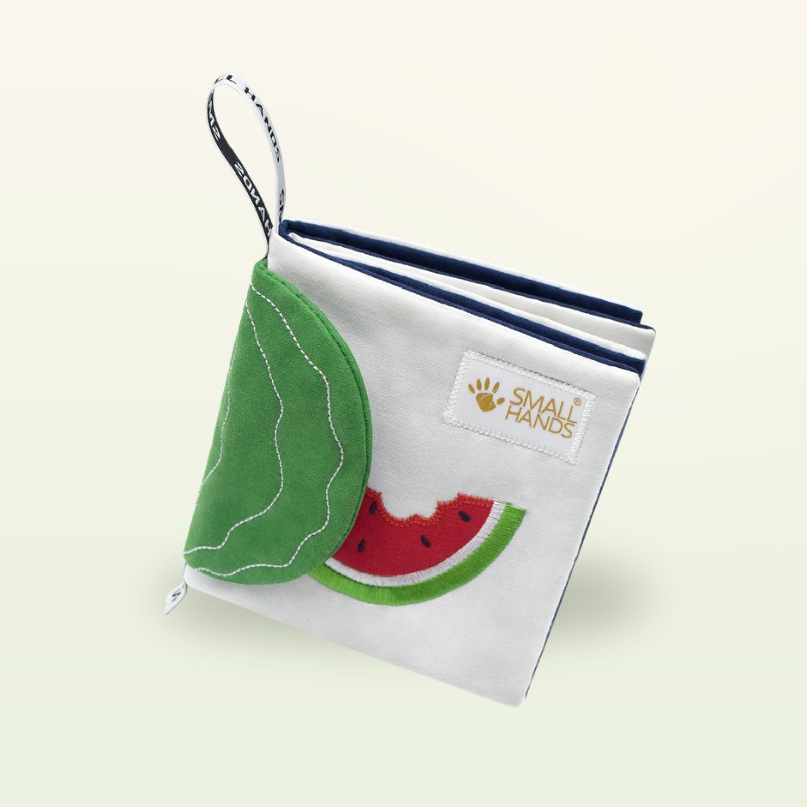 Small Hands Exotische Früchte Montessori Stoffbuch von oben mit Wassermelone und Blatt-Flap auf sanftem Creme-Hintergrund – ab 0 Monaten