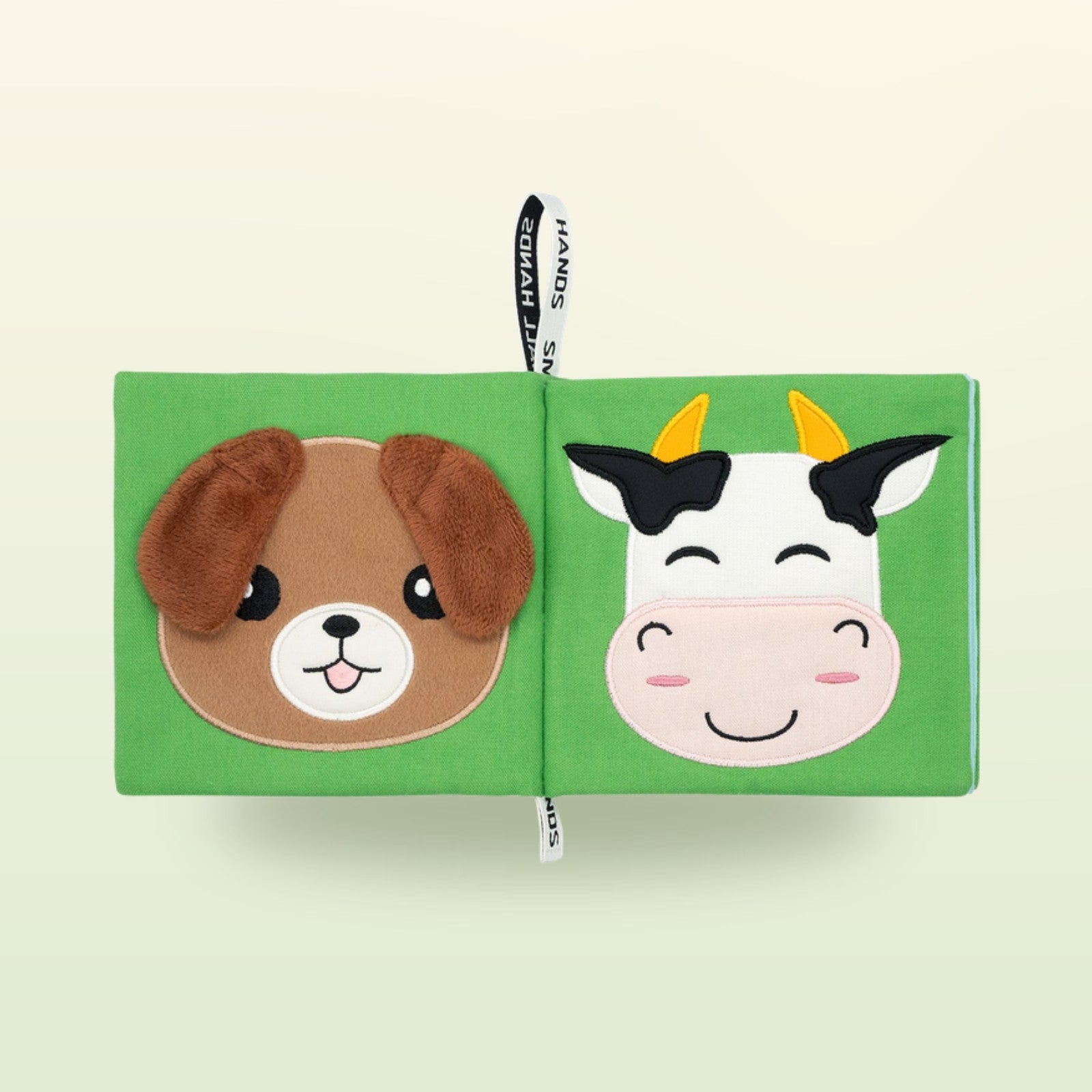 My First Book Small Hands Bauernhof Stoffbuch Doppelseite mit Hund und Kuh auf sanftem Wiesengrün-Hintergrund – ab 0 Monaten