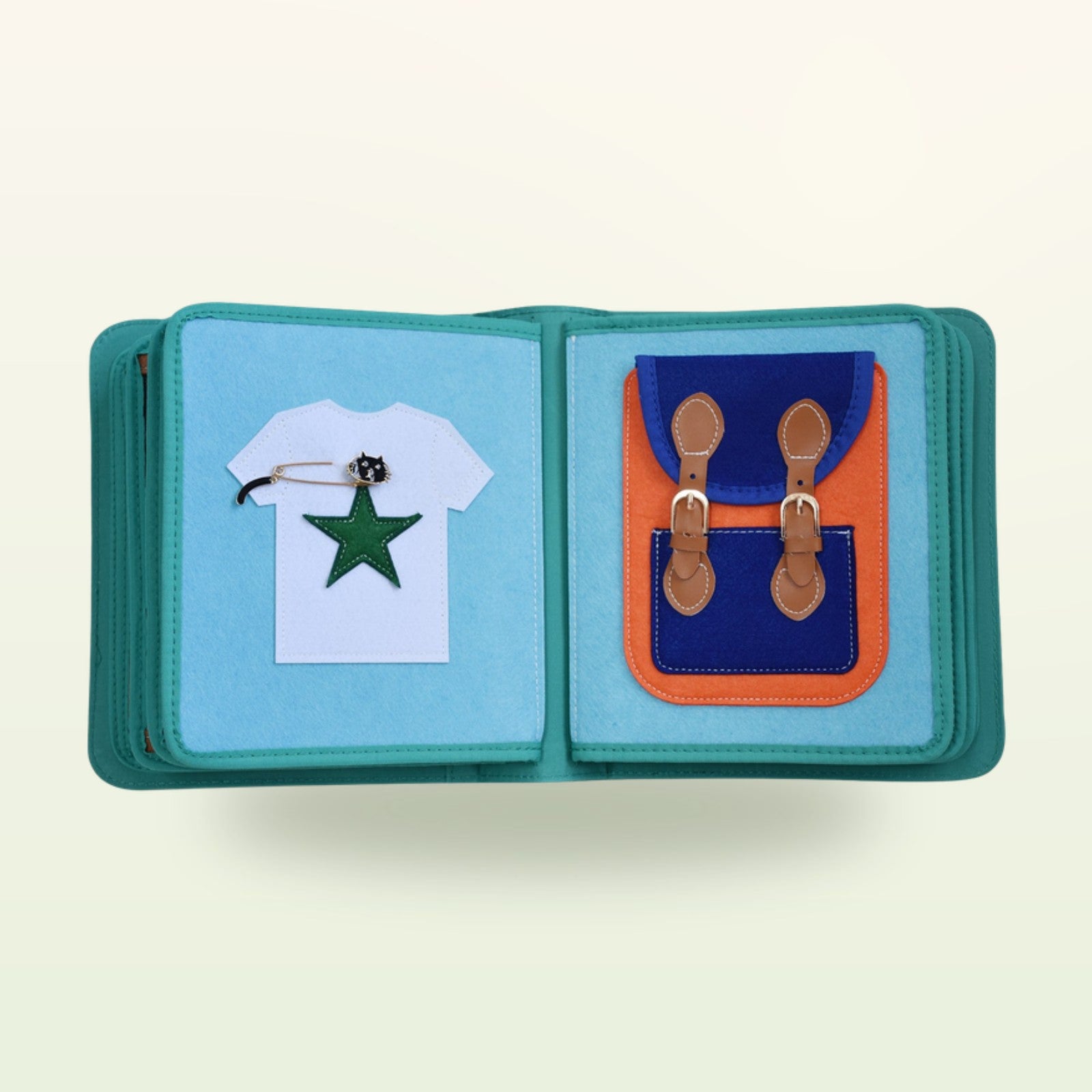 Kleiderschrank Quiet Book Stoffseite mit weißem T-Shirt mit Sternapplikation und Rucksack mit Schnallen auf sanftem Creme-Hintergrund – ab 3 Jahren
