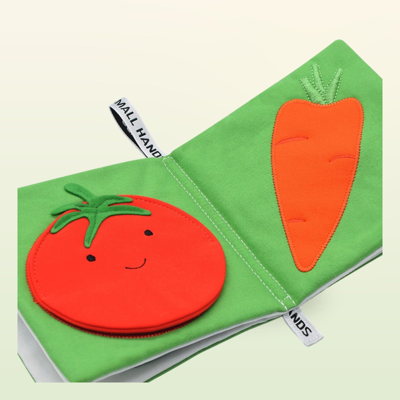 Small Hands Gemüse Montessori Stoffbuch Nahaufnahme mit Tomate und Karotte auf sanftem Wiesengrün-Hintergrund – ab 1 Jahr