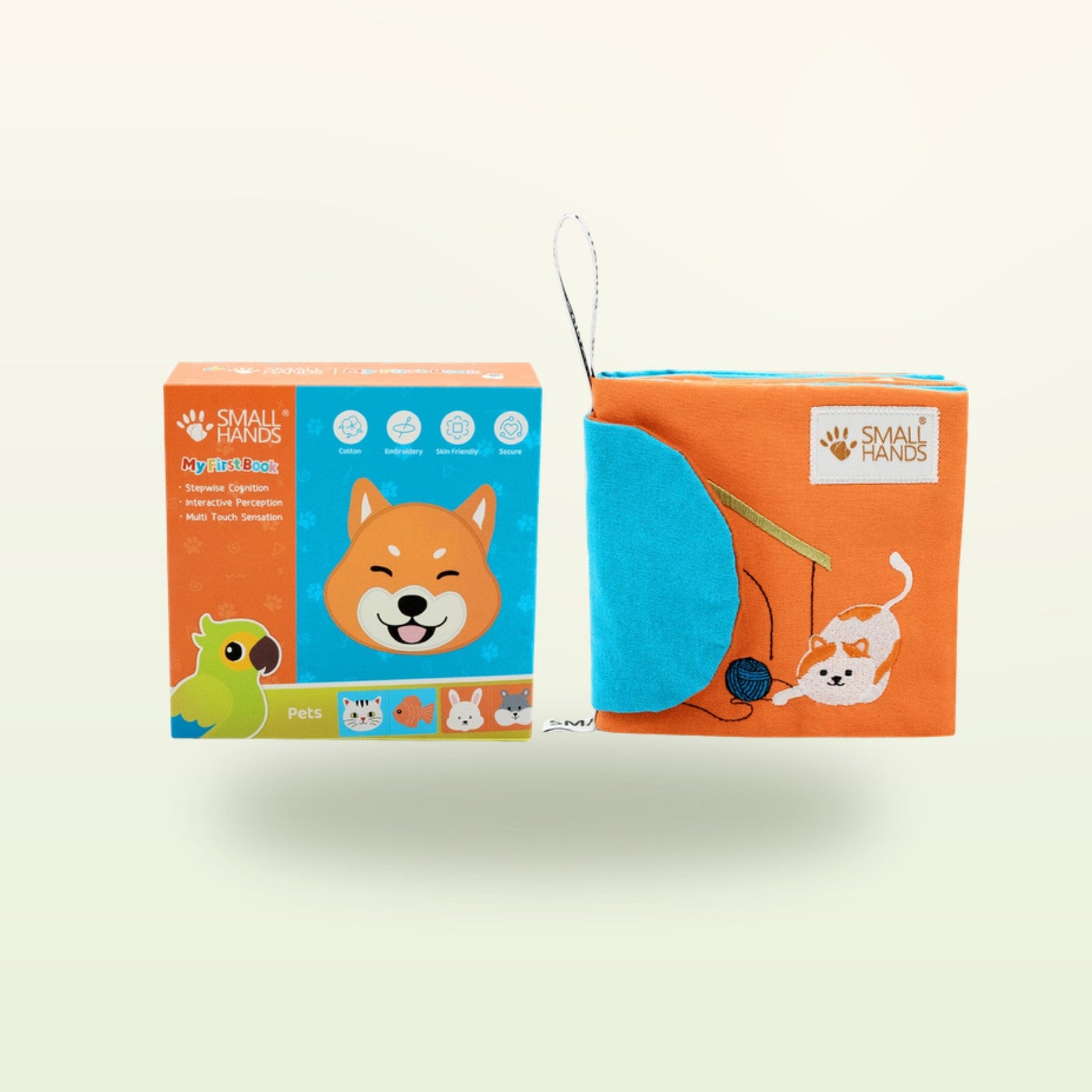 Small Hands Haustiere Montessori Fühlbuch – Verpackung mit Buch, Shiba-Hund und spielender Katze auf sanftem Creme-Hintergrund – ab 0 Monaten