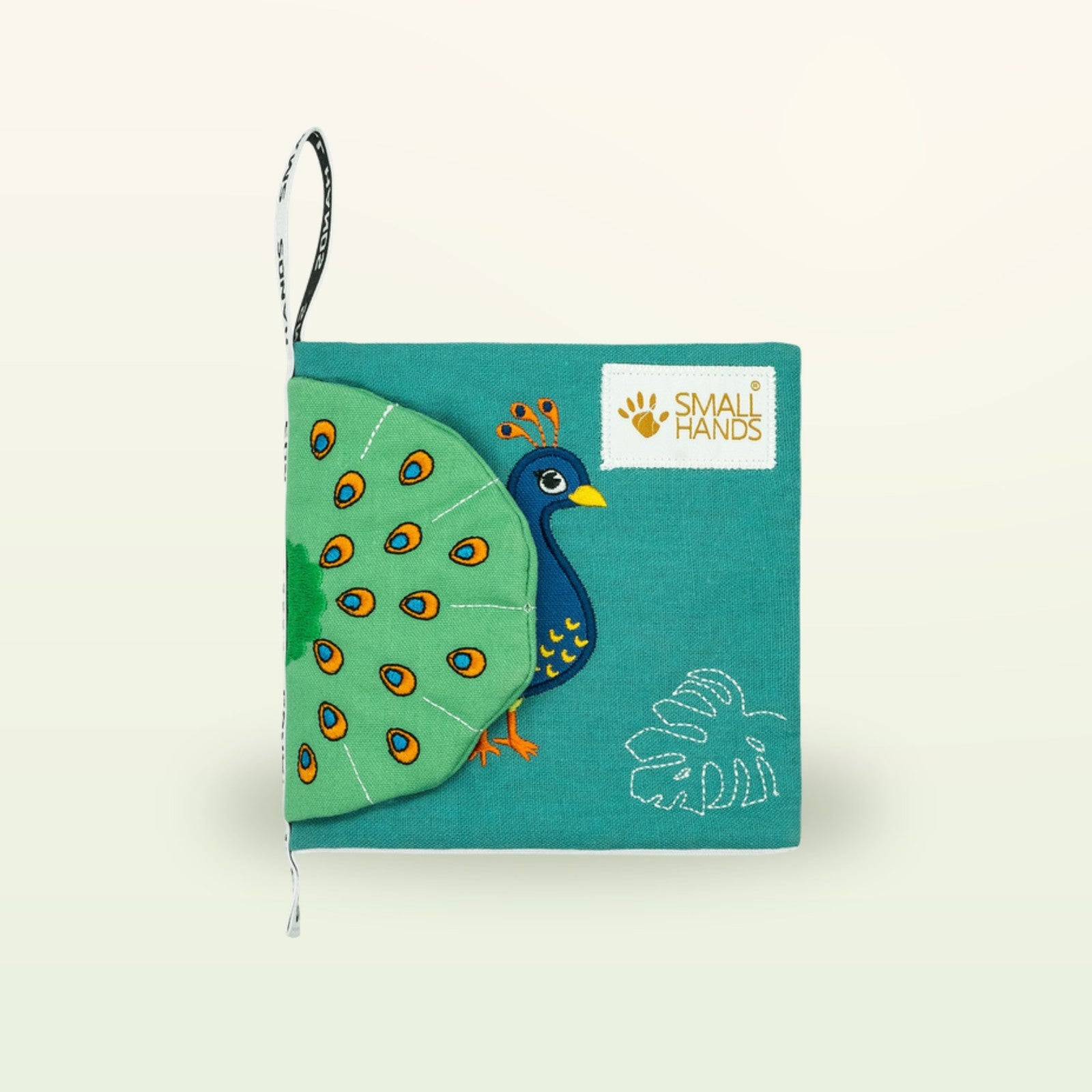 Small Hands Vögel Montessori Stoffbuch – geschlossenes Cover mit aufgesticktem Pfau und Monstera-Blatt auf sanftem Creme-Hintergrund – ab 0 Monaten