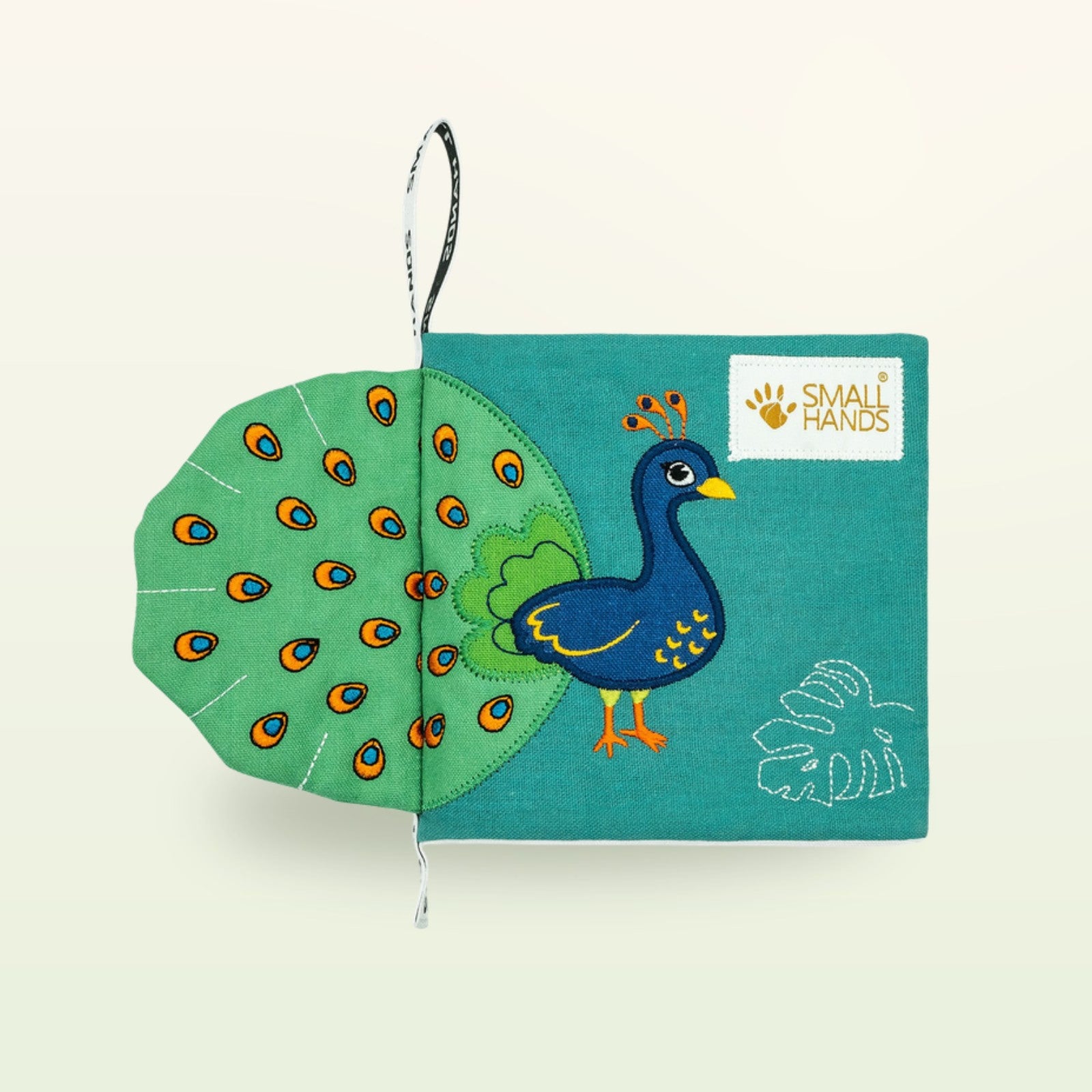 Small Hands Vögel Montessori Stoffbuch – Cover mit ertastbarem Pfau und grünem Fächer-Schwanz auf sanftem Creme-Hintergrund – ab 0 Monaten