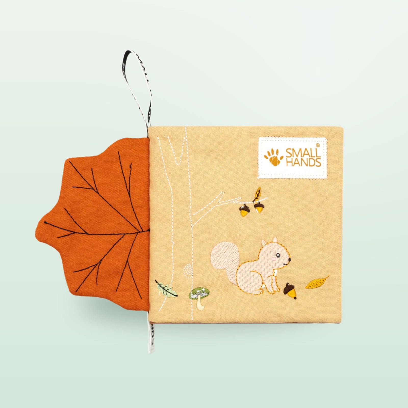 Small Hands Wilde Tiere Sensorik-Stoffbuch Cover mit Eichhörnchen und fühlbarem Ahornblatt auf sanftem Waldgrün-Hintergrund – ab 0 Monaten