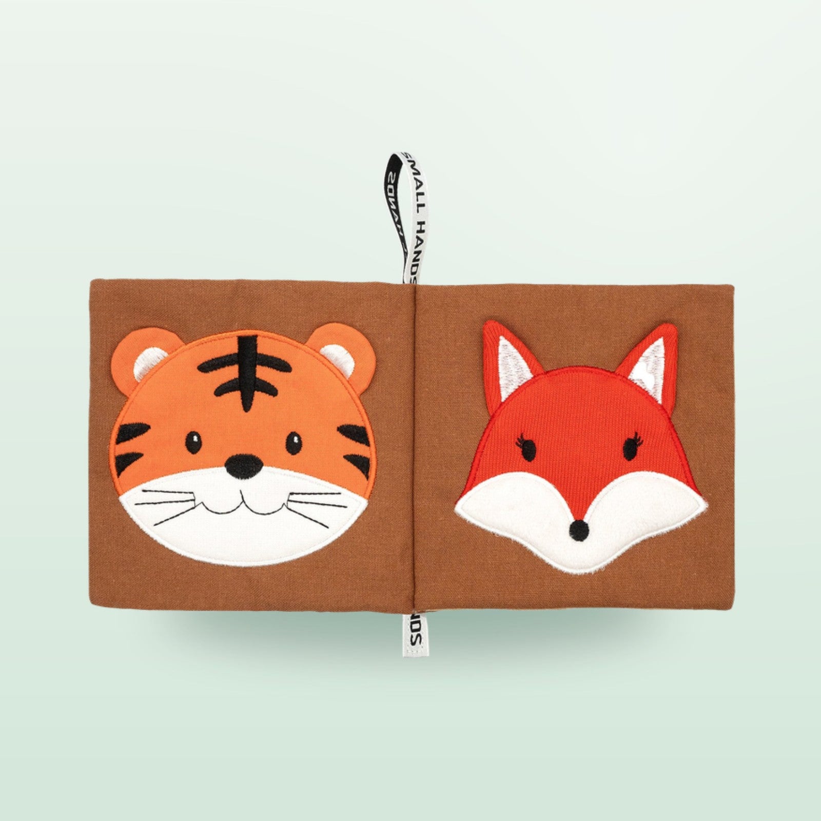 Small Hands Wilde Tiere Sensorik-Stoffbuch Doppelseite mit Tiger und Fuchs auf sanftem Waldgrün-Hintergrund – ab 0 Monaten