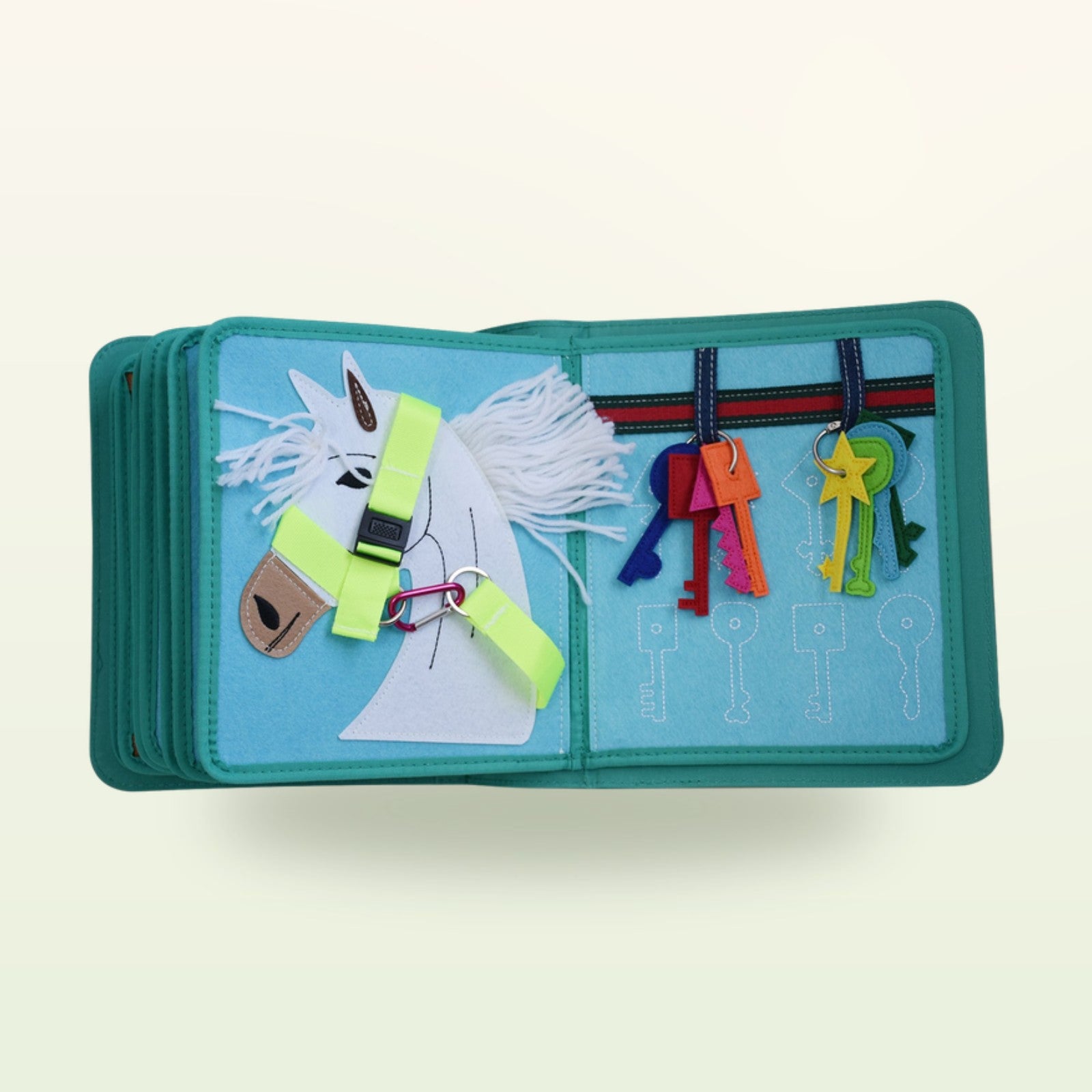 Kleiderschrank Quiet Book Stoffseite mit Pferdekopf mit Halfter-Schnalle und bunten Schlüsseln zum Zuordnen auf sanftem Creme-Hintergrund – ab 3 Jahren