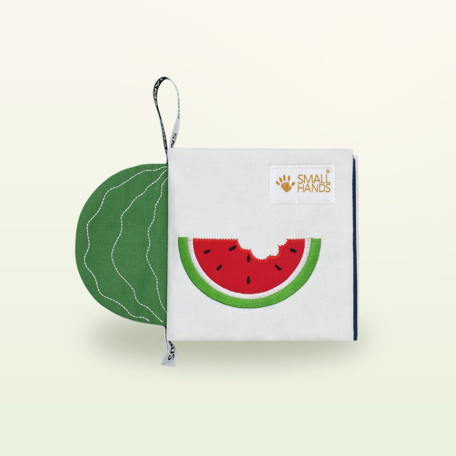 Small Hands Exotische Früchte Montessori Stoffbuch – Einband mit angebissener Wassermelone auf sanftem Creme-Hintergrund – ab 0 Monaten