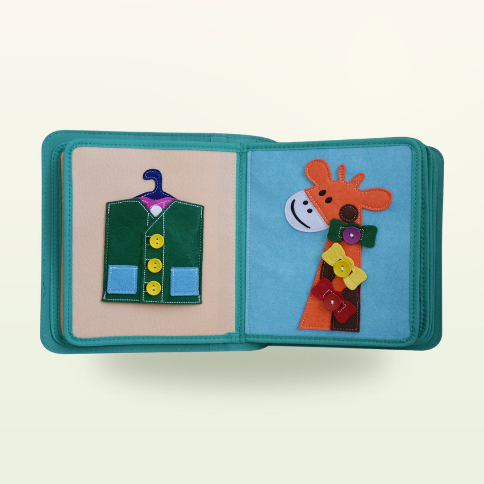 Kleiderschrank Quiet Book Stoffseite mit grüner Knopfweste am Bügel und Giraffe mit bunten Knöpfen auf sanftem Creme-Hintergrund – ab 3 Jahren
