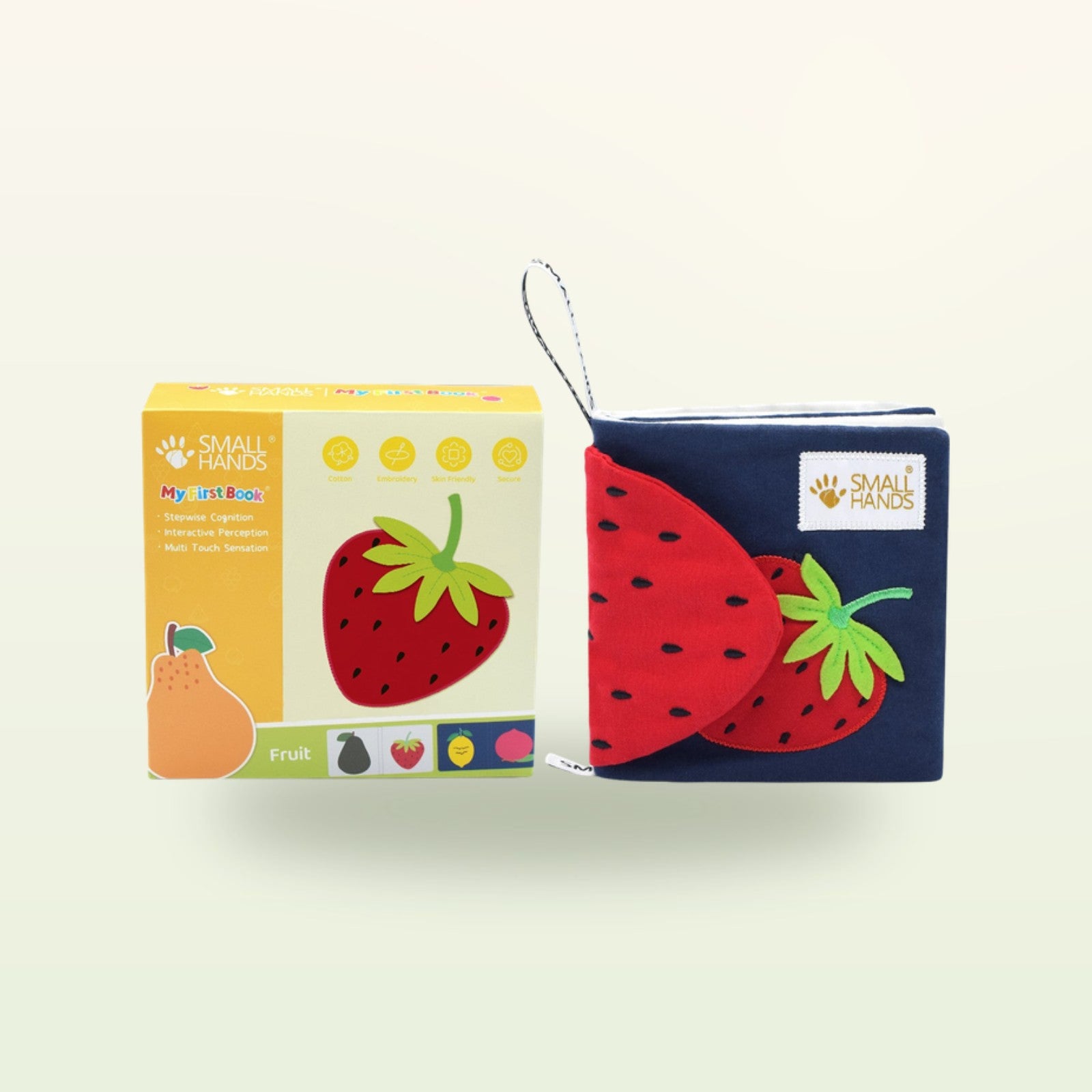 Small Hands Bunte Früchte Montessori Fühlbuch – Verpackung mit Buch und roter Erdbeere auf sanftem Creme-Hintergrund – ab 0 Monaten