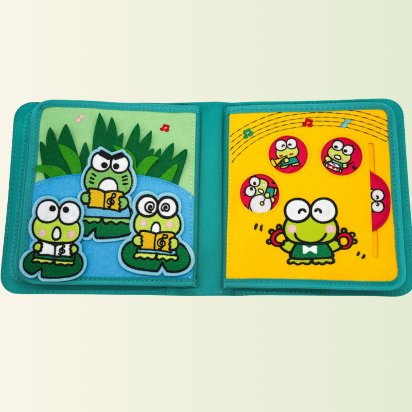 Keroppi Quiet Book – Froschkonzert mit Schieber, freigestellt auf sanftem Wiesen-Hintergrund