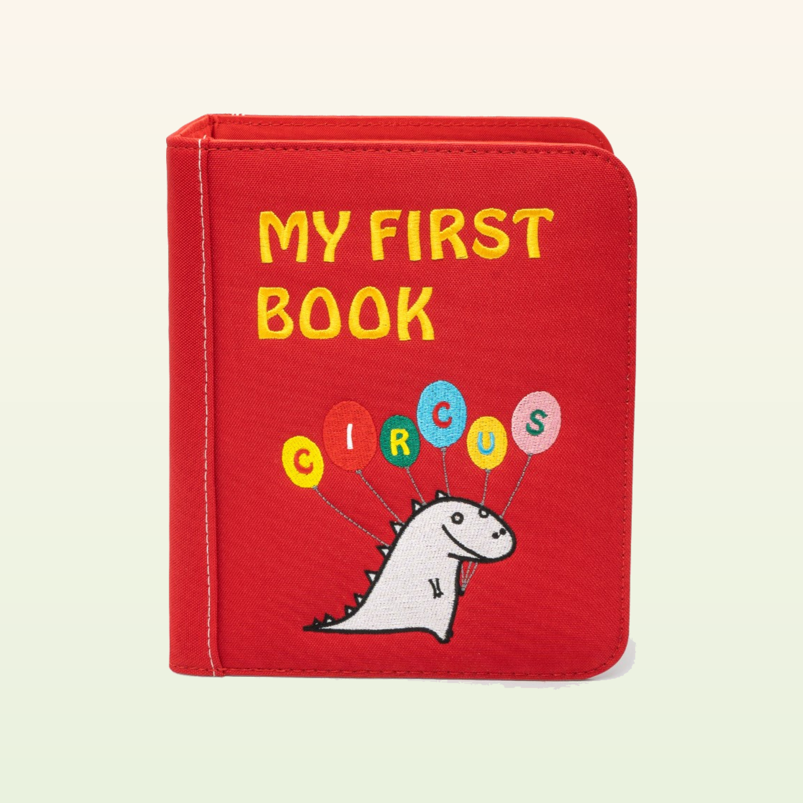 Zirkusabenteuer Quiet Book geschlossen – rotes MY-FIRST-BOOK-Circus-Cover mit Dino auf sanftem cremefarbenem Hintergrund