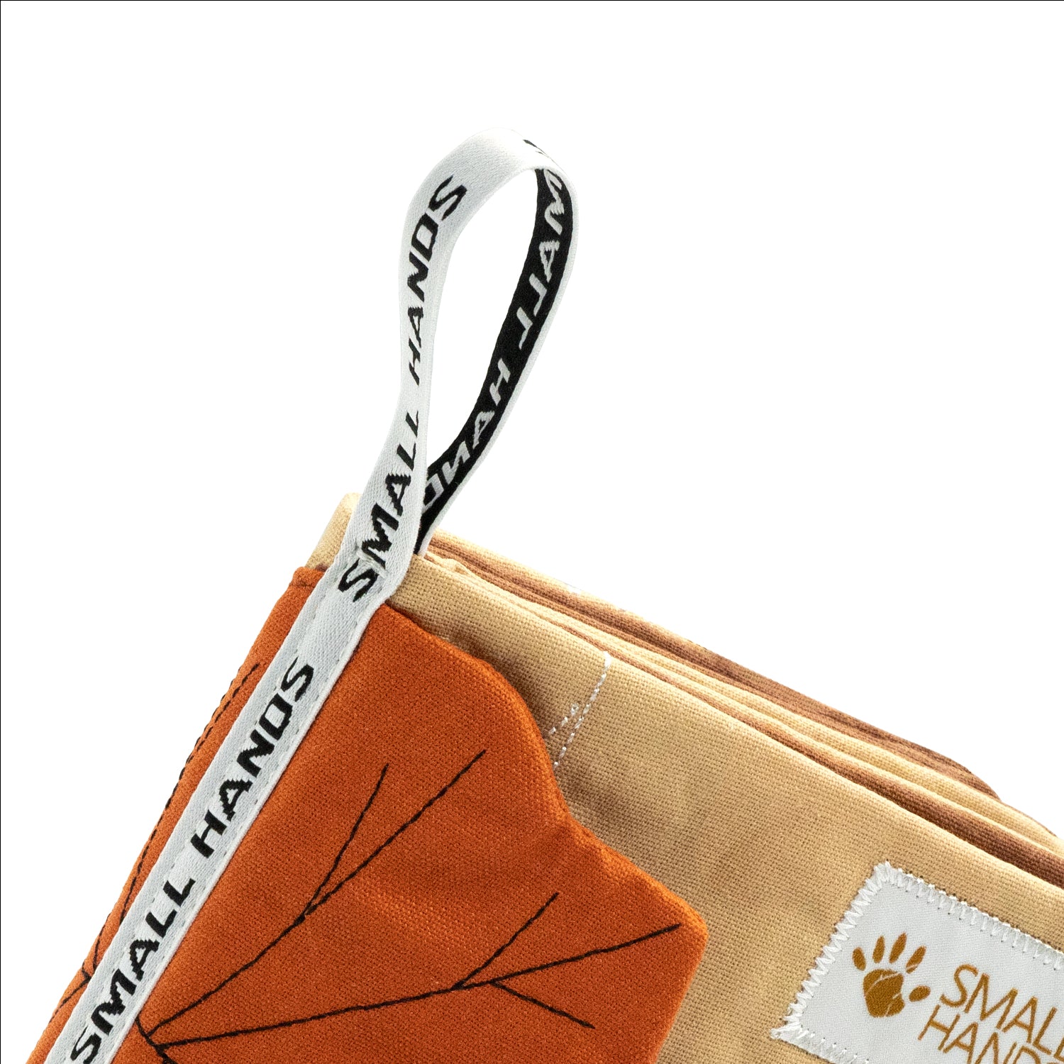 Small Hands Stoffbuch Wilde Tiere: Nahaufnahme der gewebten Greifschlaufe mit Small-Hands-Schriftzug, ertastbares Ahornblatt und weiche Stoffseiten – Babybuch-Detail